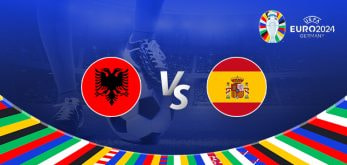 A promotional graphic for the Euro 2024 football match between Albania and Spain. The image features the national flags of Albania (a red flag with a black double-headed eagle) and Spain (a red and yellow horizontal bicolor with the national coat of arms) positioned on either side of a large "Vs" in the center. The background shows a football stadium under bright lights with a close-up of a player's leg and a football. The Euro 2024 logo and the word "Germany" are displayed in the top right corner, while a colorful border with various national flags decorates the bottom edge.