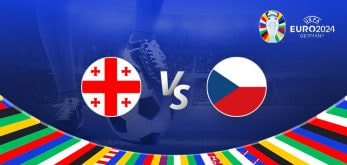 The image is a promotional graphic for the Euro 2024 football match between Georgia and the Czech Republic. It features the national flags of Georgia (a white background with five red crosses) and the Czech Republic (a flag with white, red, and blue colours). The flags are positioned on either side of a large "Vs" in the centre. The background depicts a football stadium under bright lights, with a close-up of a player's leg and a football at the bottom. The top right corner displays the Euro 2024 logo along with the tournament name and location, "Germany." The bottom edge is adorned with a colourful border featuring various national flags.