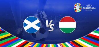 Promotional graphic for the Euro 2024 football match between Scotland and Hungary. It features the national flags of Scotland (a white saltire on a blue background) and Hungary (horizontal tricolour of red, white, and green) positioned on either side of a large "Vs" in the center. The background displays a football stadium illuminated under bright lights, with a close-up of a player's leg and a football at the bottom. The Euro 2024 logo and "Germany" are shown in the top right corner, while a colorful border with various national flags decorates the bottom edge.