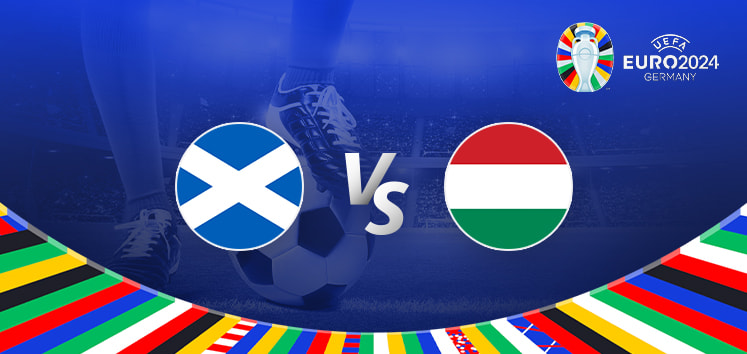 Promotional graphic for the Euro 2024 football match between Scotland and Hungary. It features the national flags of Scotland (a white saltire on a blue background) and Hungary (horizontal tricolour of red, white, and green) positioned on either side of a large "Vs" in the center. The background displays a football stadium illuminated under bright lights, with a close-up of a player's leg and a football at the bottom. The Euro 2024 logo and "Germany" are shown in the top right corner, while a colorful border with various national flags decorates the bottom edge.