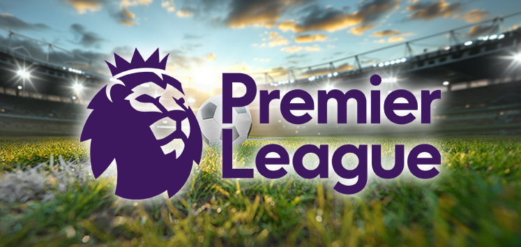 The image shows the Premier League logo, featuring a stylized lion's head with a crown, against the backdrop of a football stadium at sunset. A football is visible on the green grass pitch, with stadium lights shining, suggesting the anticipation of an exciting matchday atmosphere.